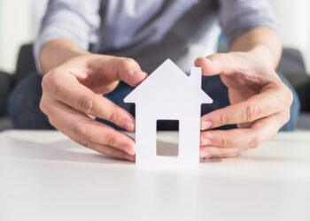 businessmen hold house model in hand