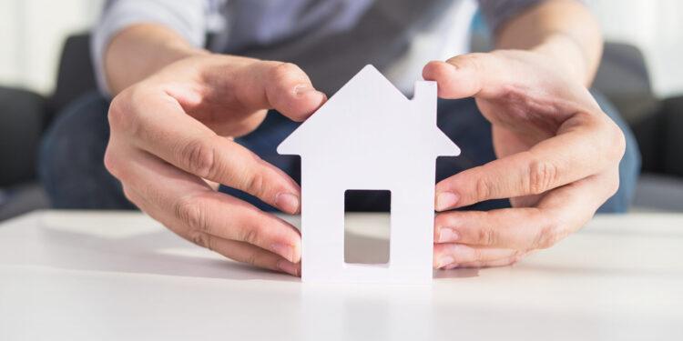 businessmen hold house model in hand
