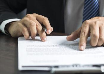 businessman or lawyer reading and signing on contract paper on table in office, concept as insurance and manager