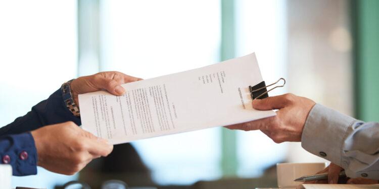 Business person giving partnership agreement to coworker