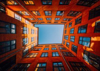 A low angle shot of a unique high rise orange building touching the sky