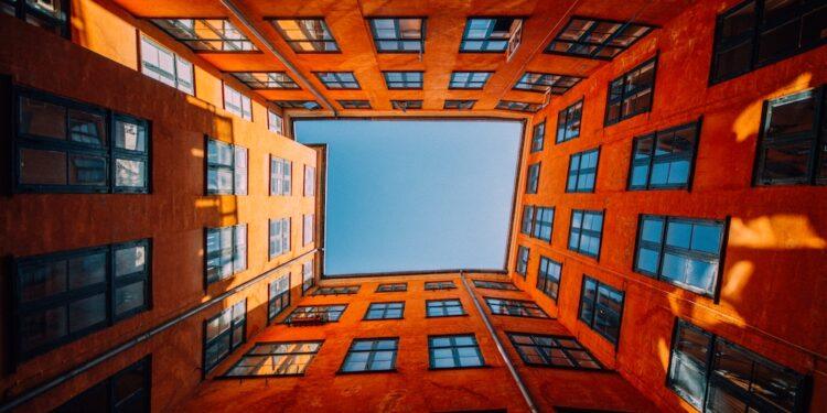 A low angle shot of a unique high rise orange building touching the sky