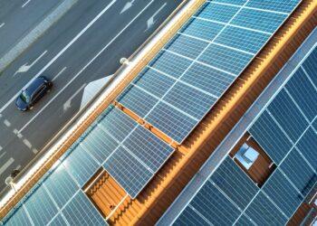 Top view of blue solar photo voltaic panels system on apartment building roof top. Renewable ecological green energy production concept.