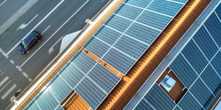 Top view of blue solar photo voltaic panels system on apartment building roof top. Renewable ecological green energy production concept.