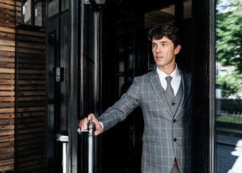 Successful middle aged businessman in suit leaving office building