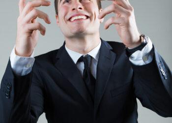 Portrait of young man in formalwear throwing money.